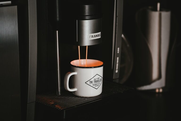 Mitarbeiter trinken Kaffee an der Büromaschine in einem modernen Münchner Büro