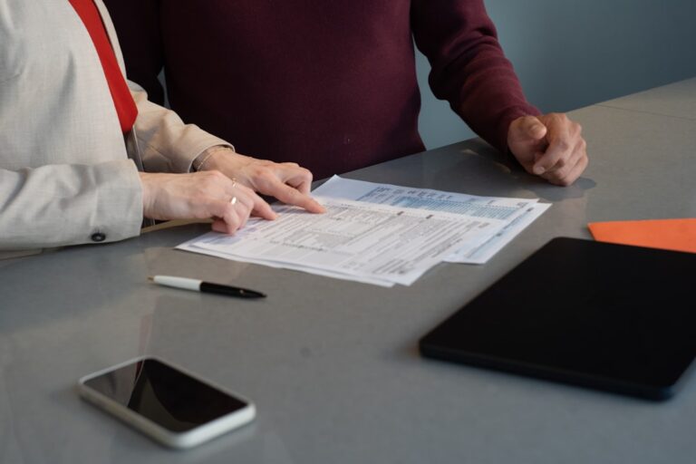Person unterschreibt Arbeitsvertrag an einem Büroschreibtisch
